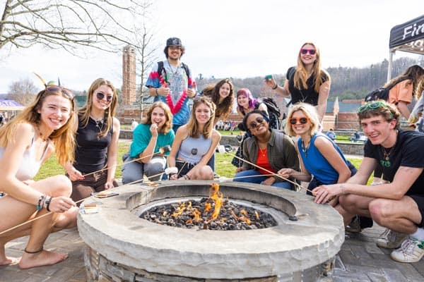 students roasting marshmallows at firepit